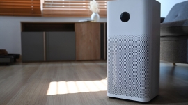 Indoor Air purifier on wooden floor in living room for filter and cleaning removing dust PM2.5 and virus.