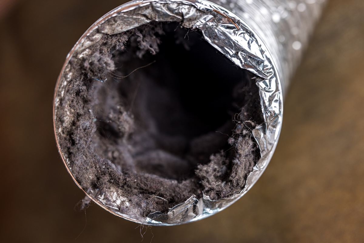 A dirty laundry flexible aluminum dryer vent duct ductwork filled with lint, dust and dirt.