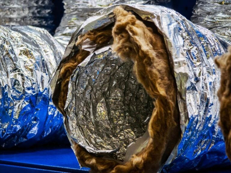 duct insulation types Insulated ducting materials arranged neatly in a storage facility showcasing construction supplies