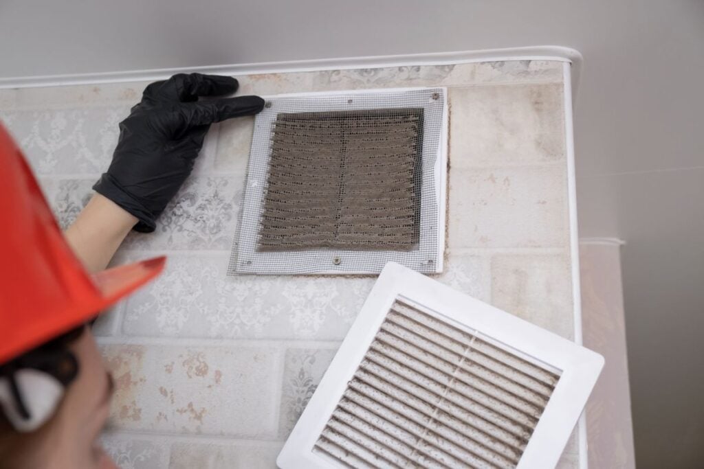 condensation on ac vent worker inspecting old dirt vent
