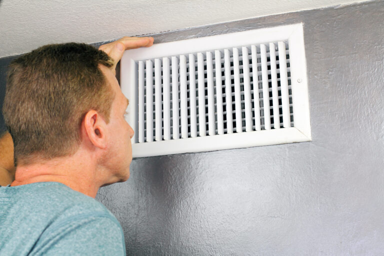 air duct cleaning tools A person cleaning with a brush an HVAC return air vent grille and duct
