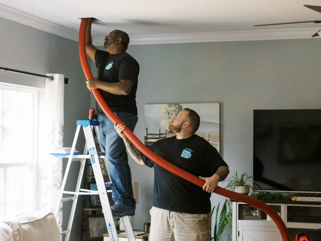 is air duct cleaning worth it Pro Shine workers using hose