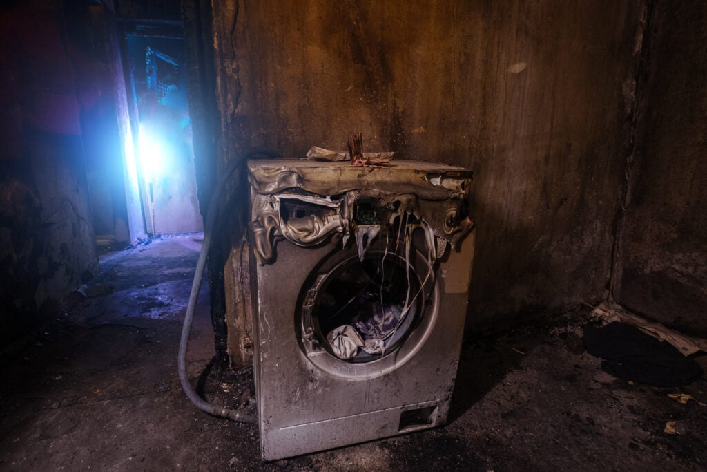 dryer fire prevention Burnt house interior. Fused remains of furniture and washing machine.